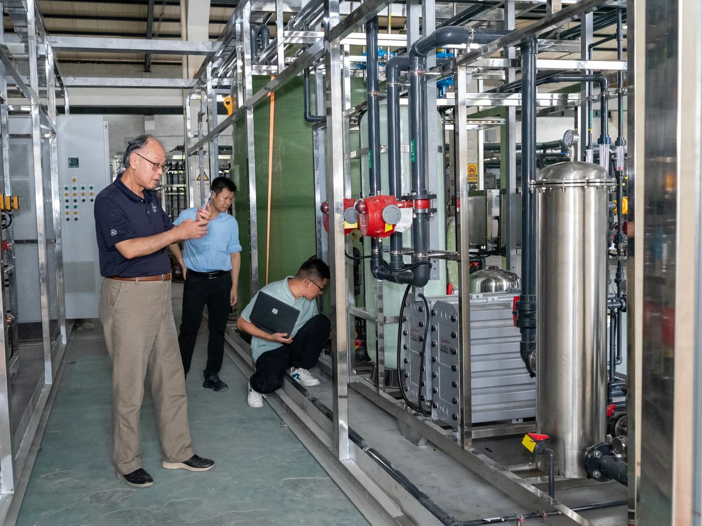 Engineers inspecting an industrial high-purity water treatment system