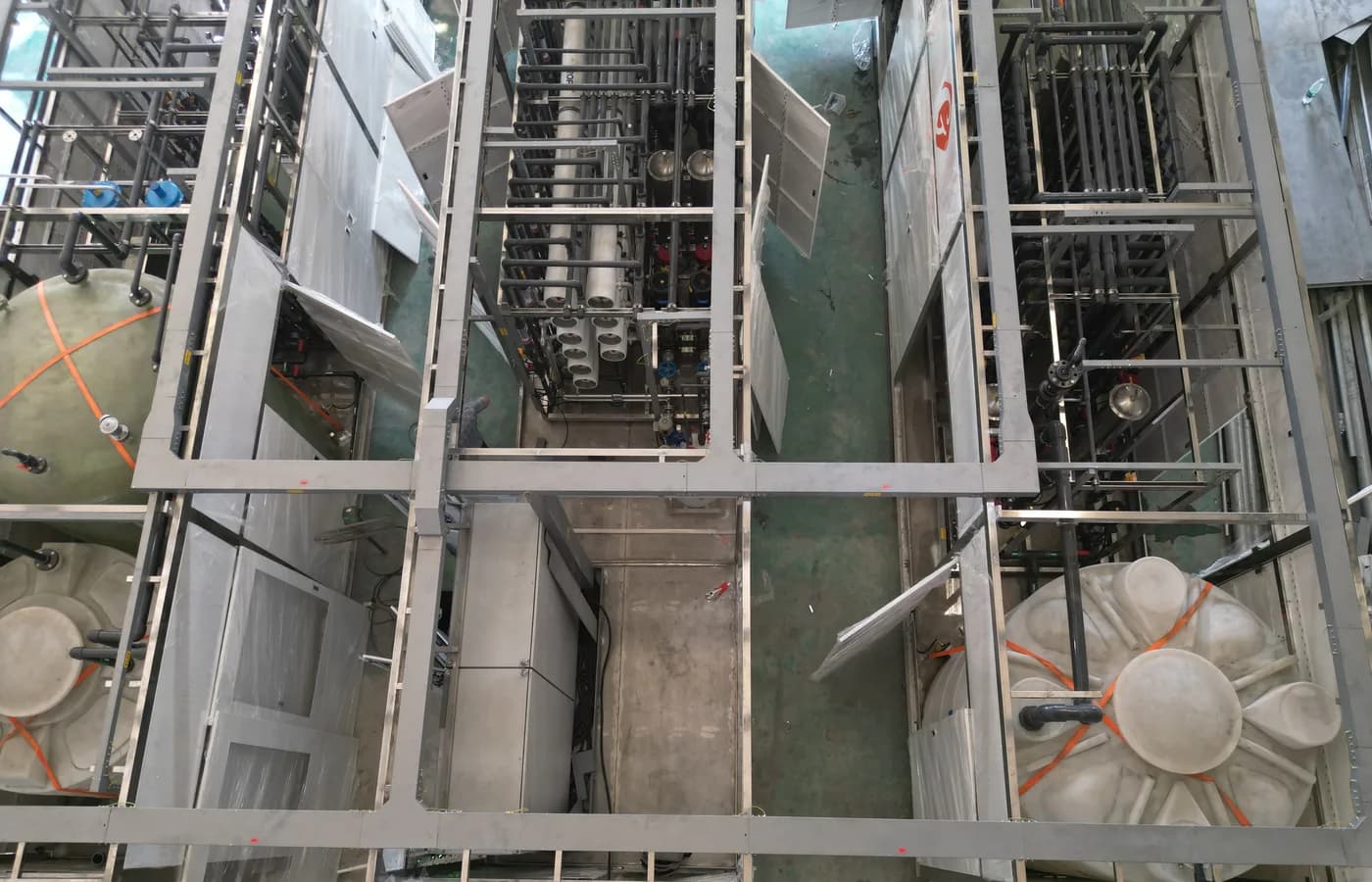 Industrial pure-water treatment train with process piping under factory assembly